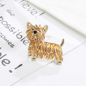 Golden terrier dog brooch with yellow enamel finish on a white decorative card