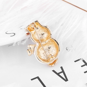 Golden alloy Christmas snowman brooch with high-quality pin back on elegant background