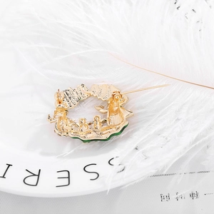 Back view of gold plated Christmas snowman wreath brooch with green enamel details