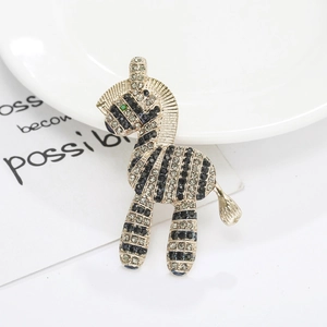 Elegant gold-tone zebra brooch set with black and white rhinestones on white display
