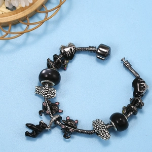 Pulsera de plata 925 con dijes de gato negro y cuentas de corazón en fondo azul