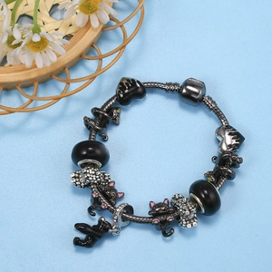 Pulsera de cadena de serpiente con dijes de gato negro y cuentas de corazón en fondo azul