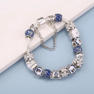 Pandora-style spring bracelet with blue floral charms and white daisies on silver snake chain