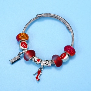 Bracelet en maille argentée avec perles en verre rouges et breloque talon aiguille rouge