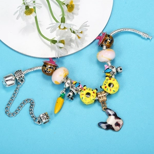 Colorful charm bracelet with unicorn, pumpkin, and donut charms on a silver snake chain
