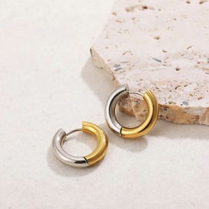 Classic two-tone 18K gold and silver stainless steel hoop earrings on stone