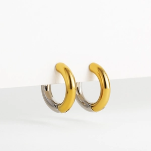 Macro shot of 18K gold and silver two-tone stainless steel hoop earrings on display