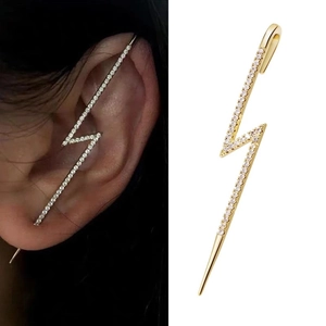 Golden lightning bolt ear crawler with zircon stones and pearls on dark background