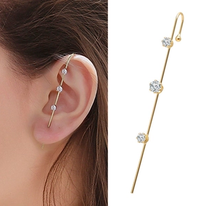 Detail of gold ear crawler featuring three round cubic zirconia and curved metal hook