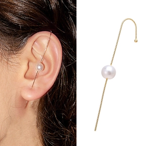 Detail of minimalist gold pearl ear cuff showing side profile and on-ear look