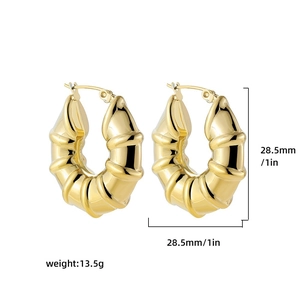 Macro detail of 28.5mm golden twisted hoop earrings with thick textured bamboo design