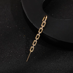 Close-up of golden geometric chain drop earrings with sparkling zircon inlay details