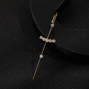 Macro view of gold-plated lightning cross earring featuring sparkling inlaid zircons