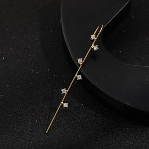 Detailed macro view of gold bar piercing stud with six sparkling zircons on black stand