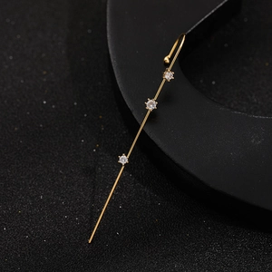 Detailed view of gold lightning bar earring with three inlaid round cubic zirconia stones