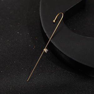 Detailed view of a minimalist golden ear hook featuring a sparkling zircon stone inlay