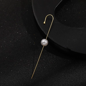 Macro detail of a minimalist gold ear hook featuring a single round white pearl accent