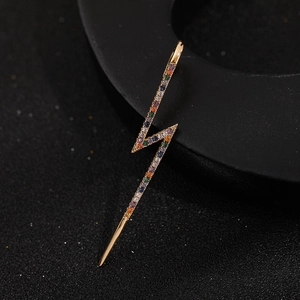 Detailed macro view of gold lightning earrings with multi-color micro-set zircon stones