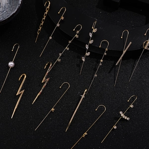Detail view of assorted gold ear crawlers with lightning bolts, pearls and colorful zircons