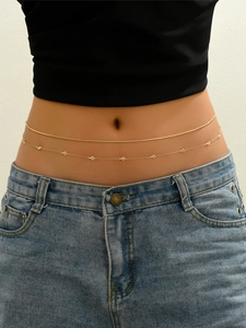 Detailed view of a double-layered gold body chain with triangle pendants on the waist