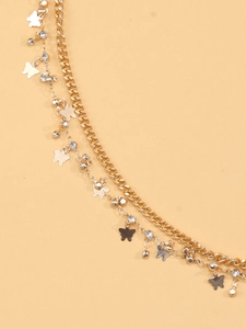 Detail of gold double-layer body chain featuring metal butterflies and sparkling crystals