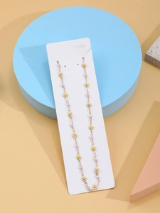 Detail of daisy flower and pearl necklace on jewelry card against geometric props
