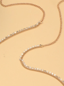 Detailed view of layered gold body chain featuring textured metallic sequin charms