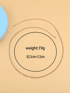 Detailed view of gold layered belly chain with round sequins and sizing measurements