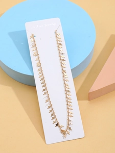 Detail of gold layered body chain with multiple cross pendants on display card