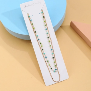 Detail of colorful beads on double-layered gold body chain with star and flower charms