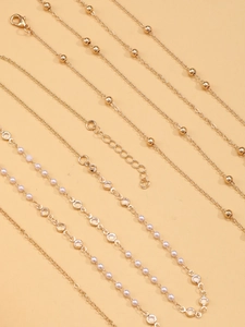 Detail of gold-plated chains with sparkling crystals, pearls, and star fringe fringe