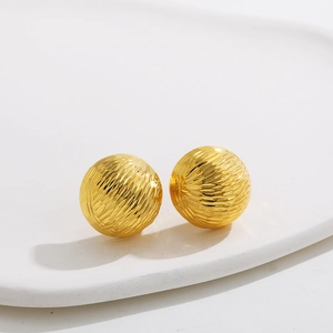 Detail of 18K gold stainless steel ball earrings with spiral textured surface design