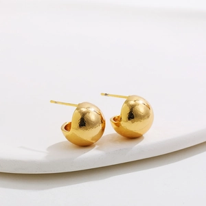 Macro detail of 18K gold-plated stainless steel domed earrings with textured glossy finish