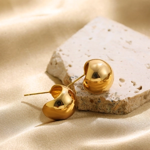 Polished 18K gold stainless steel geometric stud earrings on a stone with silk