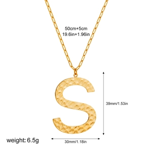 Detailed view of hammered gold letter S pendant on a paperclip chain with measurements