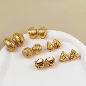 Six pairs of 18K gold plated stainless steel geometric earrings on white ceramic tray