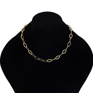 Close-up of golden flat oval link chain necklace displayed on a black velvet jewelry bust
