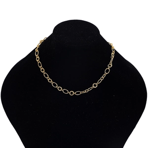 Macro detail of chunky gold chain necklace with textured links on black velvet display