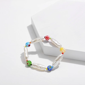 Detalle de cuentas de vidrio coloridas Y2K y perlas barrocas en una pulsera artesanal