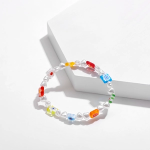 Detalle de una pulsera de cuentas Y2K de colores con perlas de corazón en soporte blanco