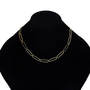 Detail view of a chunky gold paperclip link chain necklace on a black velvet neck bust