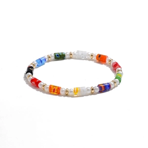 Detalle de cuentas de vidrio de colores Y2K y perlas barrocas en una pulsera artesanal viva