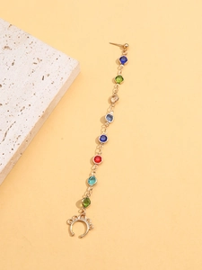 Détail de la chaîne de boucle d'oreille dorée avec perles colorées et manchette