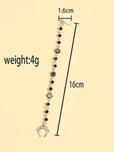 Détail d'une boucle d'oreille chaîne argentée avec perles noires et lune, 16cm