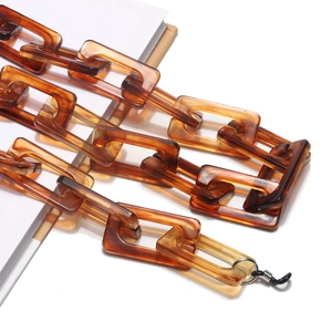 Detail view of amber acrylic eyewear chain with rectangular links and silicone loops