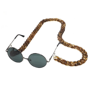 Close-up of amber acrylic chunky chain with retro thin metal frame sunglasses