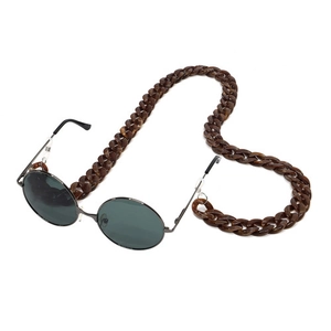 Detail of dark brown tortoiseshell acrylic glasses chain with vintage round sunglasses