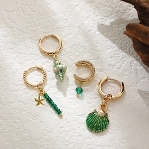 Dettaglio set orecchini con conchiglia marina stella marina e ear cuff dorati stile boho