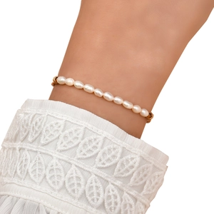 Detailed close-up of a pearl bracelet featuring golden hexagonal beads on a wrist