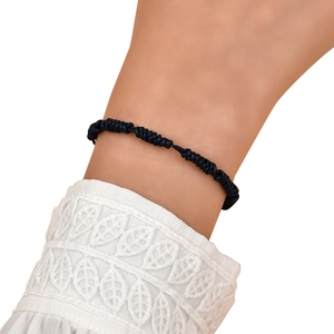 Close-up of a black handmade braided cord bracelet with intricate knotted textures